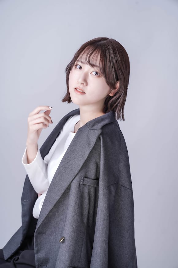 淡いグレー背景でジャケットを羽織った上半身ポートレート、ビジネスプロフィール写真の作例